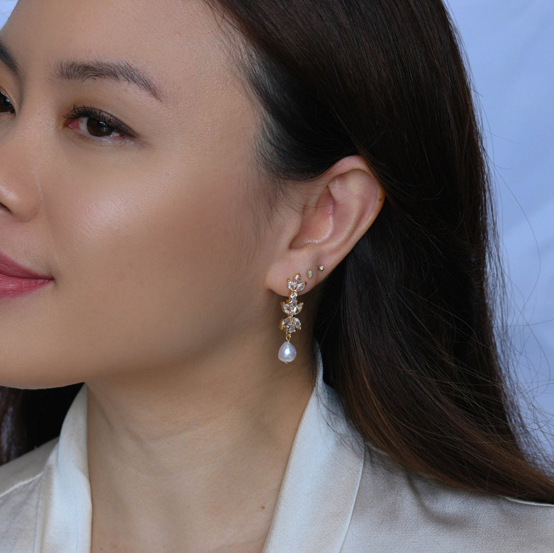 Close-up of a woman wearing a pearl earring with a blurred background